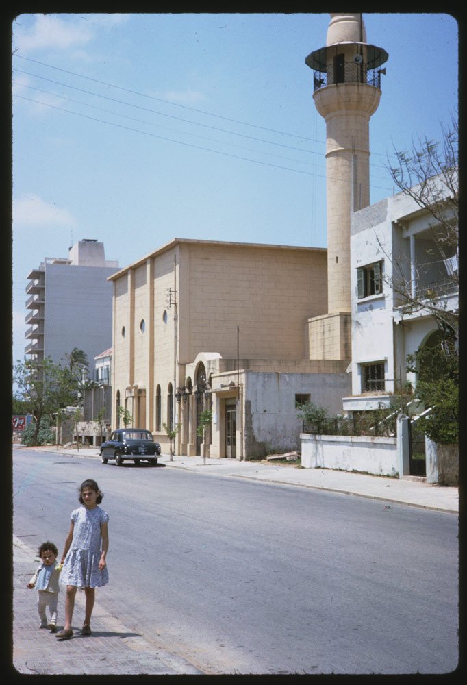 Children walked by a mosque.