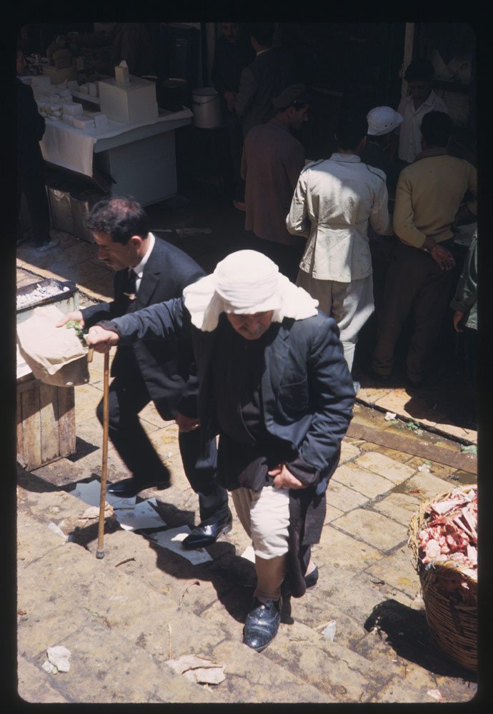 An elderly man walked through the market ...